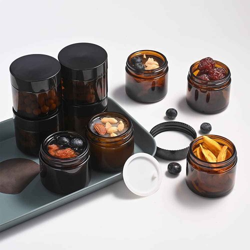 Bumobum 1 oz Amber Glass Jars with Lids, 105 pack Clear Small Jars with Black Lids, White Labels and Inner Liners, Empty Round Cosmetic Containers for Cream, Lotion (Amber 105 Pack)